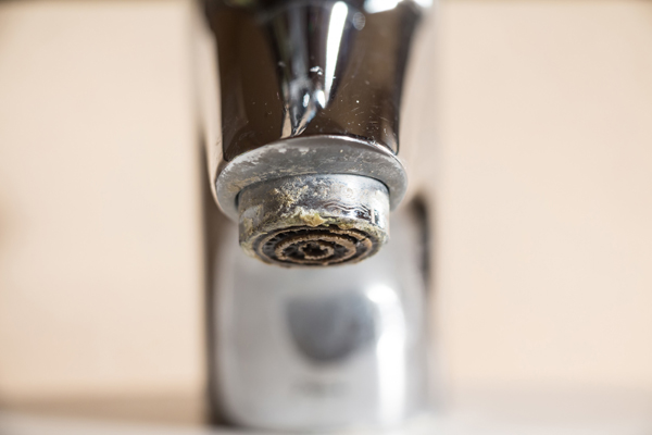 Hard water calcium deposit on chrome tap