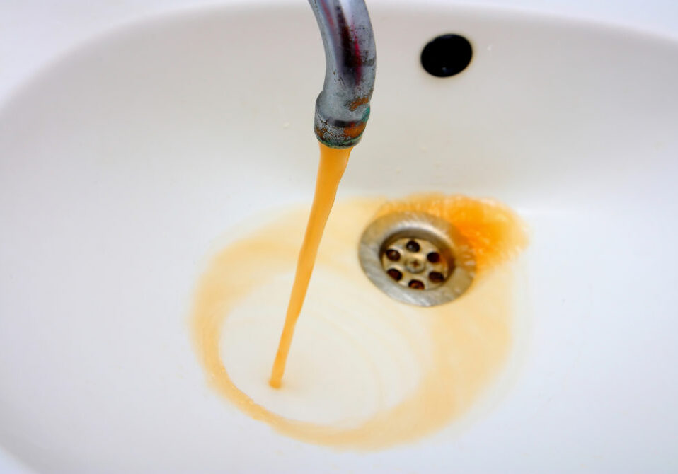 Color photography of a rusty water what run from a faucet